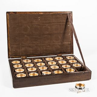 Cased Set of Twenty-four Individual Salt Cellars, each gold washed and with glass liner, (some liners chipped, oxidation to bottoms of