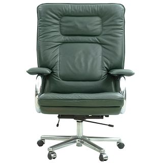 Sillón ejecutivo. Siglo XX. Estructura de metal cromado. Respaldo cerrado y asiento en tapicería de vinipiel color verde.