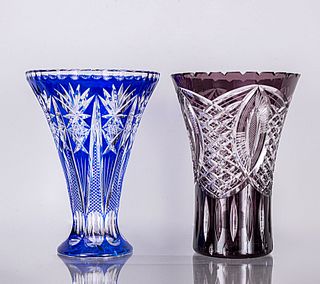 Lote de 2 floreros. Siglo XX. Elaborados en cristal de Bohemia color morado y azul. Decorados con elementos geométricos y facetados.