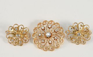 Three Piece 14 Karat Gold and Diamond Brooch and Earring Set
each set with center diamonds, approximately .35 carats, brooch with seven diamond surrou