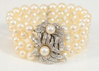Pearl Four Strand Bracelet
having large 14 karat white gold clasp, in floral design, mounted with two pearls, and diamond mounted flower petals, petal