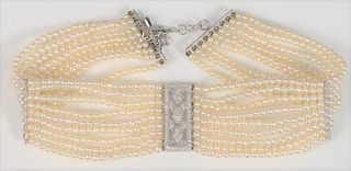 18 Karat White Gold Choker Necklace
with nine strands of pearls, gold, and diamond openwork, center and gold clasp
length 13 inches
