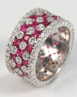18 Karat White Gold Wide Band
set with rubies, surrounded by and implanted with diamonds
band width 3/8 inches
size 6 3/4