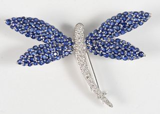 18 Karat White Gold Dragonfly Brooch 
set with blue sapphire wings, and diamond body 
width 2 1/2 inches
17.5 grams