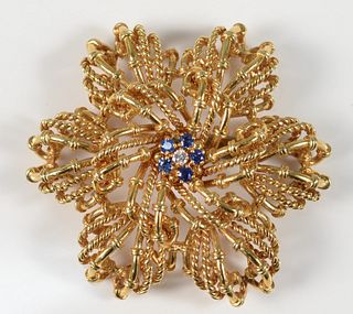 Tiffany & Company 18 Karat Gold Brooch
set with five blue sapphires, and one diamond
diameter 2 inches
35 grams
