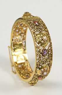 22 Karat Gold Bangle Style Bracelet
with open work, and various colored stones, marked Sonica Jewelers
39 grams