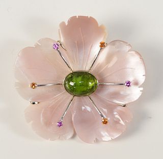 Mother of Pearl Flower Brooch
mounted in 18 karat white gold, having center green tourmaline, surrounded by sapphires
signed M.B.
diameter 2 1/2 inche