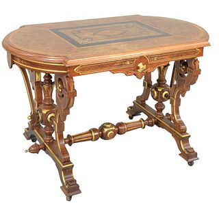 Renaissance Revival Center Table
with inlaid burlwood, shaped top on gilt decorated base and stretcher
height 29 inches, top 27 1/2" x 46"
Provenance: