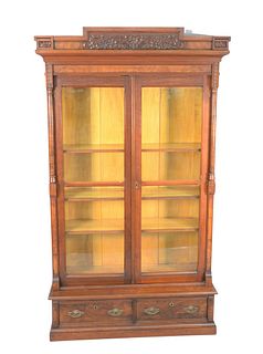 Victorian Walnut and Burl Walnut Carved Bookcase
with two doors over two drawers
height 84 inches, width 52 1/2 inches
Provenance: Matthes-Theriault C