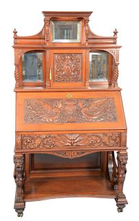 Victorian Mahogany Desk
having mirrored back, with door over carved drop lid, over carved drawer, all set on winged griffin supports, on shelf with tu