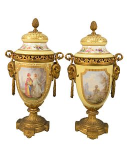 Pair of Sevres Porcelain and Gilt Bronze Urns, yellow ground with paint scenes on both sides, mounted with ram's head and loop handles, on round bronz