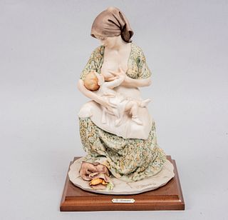 Maternidad. Italia. Siglo XX. Diseño por Giuseppe Armani. Firmada. Elaborada en pasta Capodimonte. Con base de madera. 25 x 18 x 18 cm