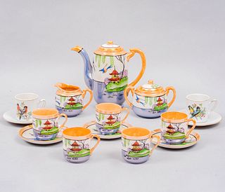 Juego abierto de té. Japón. Siglo XX. Elaborados en porcelana iridiscente. Consta de: tetera, cremera, azucarera y 5 ternos. Piezas: 13