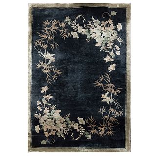 Tapete. Siglo XX. Elaborado en fibras sintéticas. Decorado con motivos vegetales y florales sobre fondo negro. 180 x 122 cm.