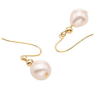 Par de aretes con perlas en oro amarillo de 14k. 2 perlas color blanco de 7 mm. Peso: 1.6 g.