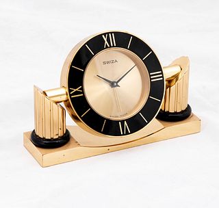 Reloj de mesa. Suiza. Siglo XX. Elaborado en metal dorado. Marca Swiza. Mecanismo de cuarzo. Con carátula circular. 9.5 x 14 x 4 cm