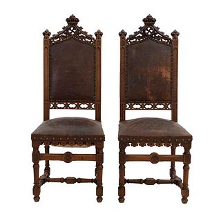 Par de sillas. Francia. Siglo XX. Estilo Enrique II. En talla de madera de nogal. Con respaldos semiabiertos.