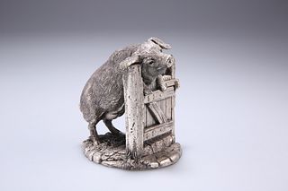 A MODERN SILVER MODEL OF A PIG, modelled peering over a sty