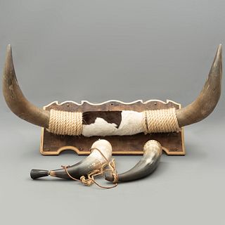 Cuernos de toro de lidia y dos depósitos para pólvora. México, siglo XX. Con base de madera.
