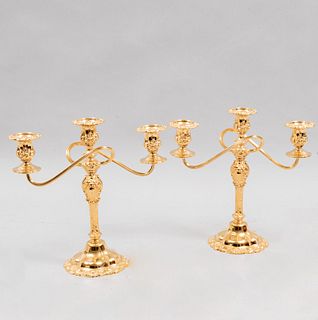 Par de candelabros. Siglo XX. Elaborados en bronce dorado. Para 3 luces. Con arandelas irregulares y brazos en "S". 28.5 x 28 x 12 cm