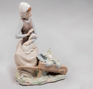 Niña recolectora con carreta. España, siglo XX. Elaborada en porcelana Lladró acabado brillante. 23 cm de altura