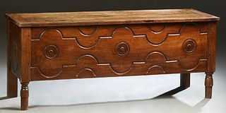 French Provincial Carved Walnut Coffer, 19th c., the three board hinged top over an incised and relief carved front and sides, on turned tapered cylin