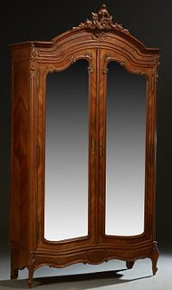 French Carved Mahogany Louis XV Style Armoire, early 20th c., the arched crown with a central pierce C-scroll Crest, over double beveled mirror doors,
