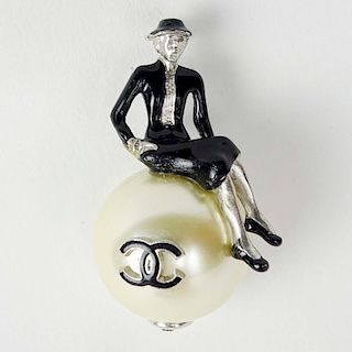 Chanel, Made in France Faux Pearl Brooch with an Enameled Seated Coco Chanel Figure. Signed.