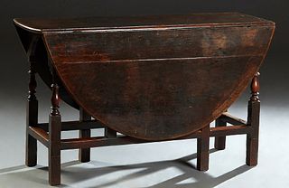 English Carved Oak Drop Leaf Dining Table, 19th c., the oval top over turned and block gate legs, joined by rectangular stretchers, H.- 29 in., W.- Cl