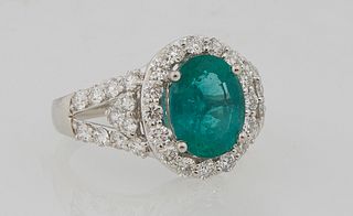 Lady's Platinum Dinner Ring, with an oval 2.27 carat emerald atop a border of round diamonds flanked by pierced diamond mounted shoulders of the band,