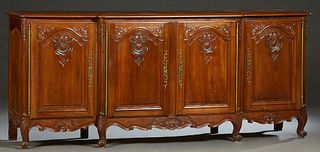 French Provincial Louis XV Style Carved Walnut Sideboard, 20th c., the parquetry inlaid rounded edge top over double fielded panel cupboard doors with
