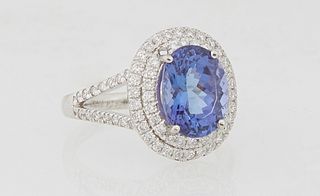 Lady's Platinum Dinner Ring, with an oval 2.76 carat tanzanite atop a double graduated concentric border of small round diamonds, the split shoulders 