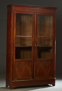 French Louis Philippe Carved Walnut Bookcase, 19th c., the stepped canted corner crown over double doors with two glazed upper panels over wood lower 