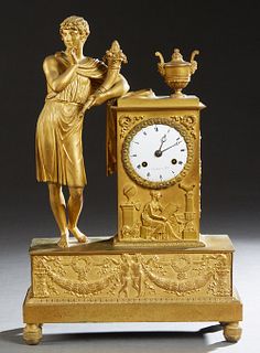 French Gilt Bronze Empire Style Figural Mantel Clock, mid 20th c., with a classically attired youth holding a cornucopia, leaning on an urn surmounted