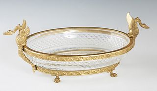 French Bronze and Crystal Sweetmeats Bowl, 20th c., of oval form, the rim with two swans' head handles, to a relief decorated oval bronze base with pa