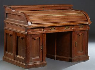 American Carved Oak Wooten Style Roll Top Desk, late 19th c., the C tambour roll over a leather inset wiring surface and rear cubby holes, over three 