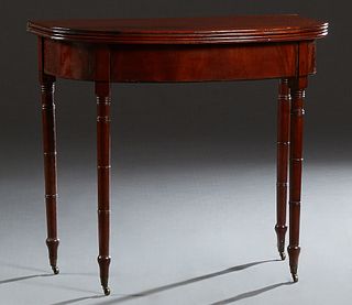 English Victorian Carved Mahoganay Demilune Gateleg Tea Table, 19th c., the reeded edge top on four turned tapered cylindrical legs with cap casters, 