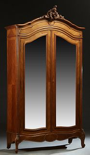 French Carved Mahogany Louis XV Style Armoire, c. 1890, the stepped arched crown with a central C-scroll crest, over double arched wide beveled mirror
