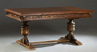 Spanish Renaissance Style Carved Oak Draw Leaf Dining Table, early 20th c., the rounded edge top over a carved skirt and two draw leaves, on run form 