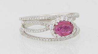 Lady's Platinum Dinner Ring, with an oval 1.09 pink sapphire atop a border of tiny round diamonds, on a four way split band mounted with tiny round di