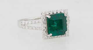 Lady's 18K White Gold Dinner Ring, with a square 2.69 carat emerald atop a triple concentric graduated diamond border, the split shoulders of the band