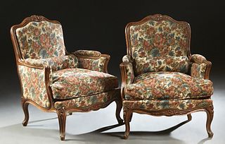 Pair of French Louis XV Style Carved Cherry Bergeres, early 20th c., the arched leaf and crest carved rail above an upholstered back and arms, to a ro