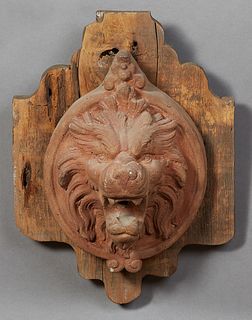 Continental Terracotta Lion's Head Fountain Spout, 19th c., now mounted on a shaped wooden back plate, H.- 17 in., W.- 12 3/4 in., D.- 17 1/2 in.