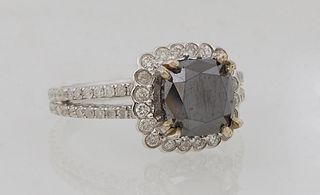 Lady's 14K White Gold Dinner Ring, with a cushion cut 3.46 carat black diamond, atop a border of round diamonds, the split shoulders of the band mount