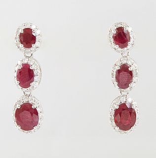 Pair of Platinum Pendant Earrings, each with three graduated oval rubies within diamond mounted borders, total diamond weight- .82 cts., total ruby we