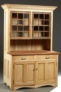Louisiana Carved Cypress Kitchen Cabinet, 20th c., the stepped rounded crown over double mullioned glazed door above open storage, on a base with two 