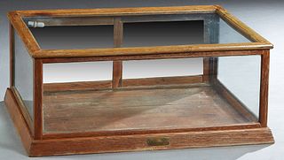 Small Carved Oak Tabletop Display Case, c. 1900, with a glazed front, top, and sides, the back with double mirror doors, on a plinth base, with a labe