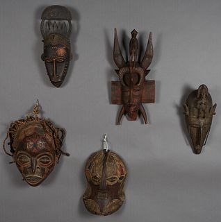 Group of Five African Carved Wood Masks, 20th c., consisting of a polychromed example, Chokwie, Angola, with braided rope "Hair;" a punched metal moun