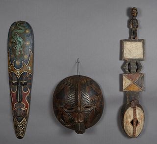Group of Three Carved Wood African Masks, 20th c., consisting of a tall narrow example with pointillist and lizard decoration; a round mask , Luba, Co