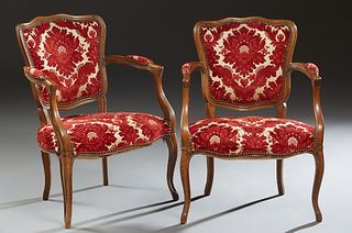 Pair of French Louis XV Style Carved Beech Upholstered Fauteuils, 20th c., the arched curved back over upholstered arms and a bowed seat, on scrolled 